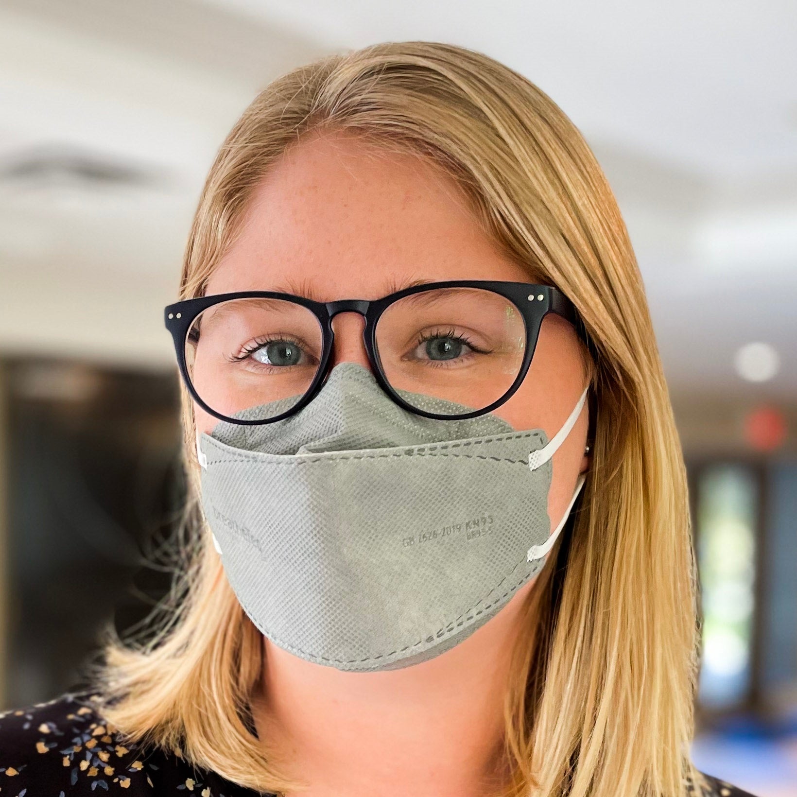 Canadian woman with glasses wearing grey BreatheTeq KN95 respirator face mask with earloops