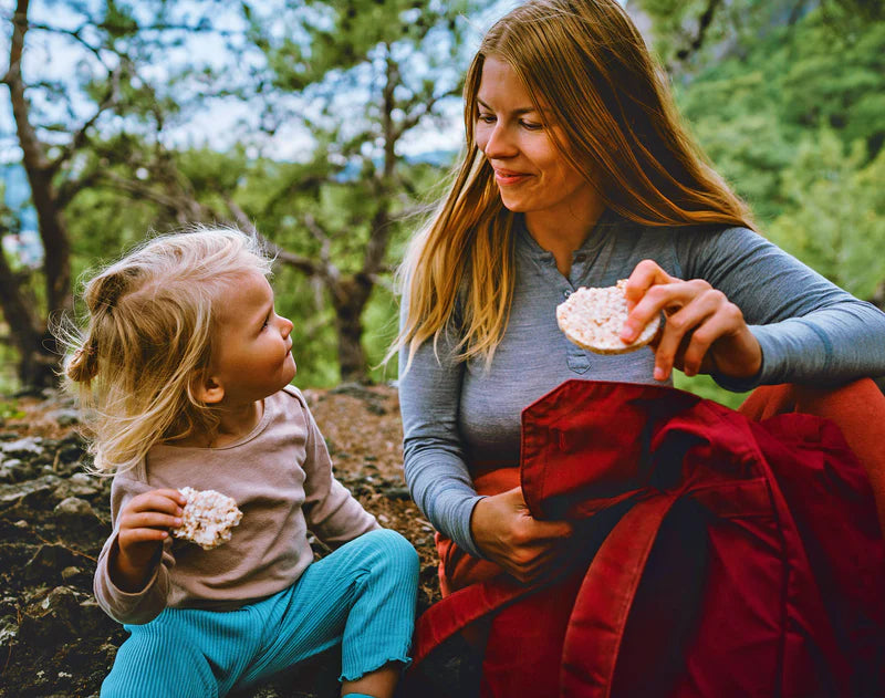 Canadian mother and child sanitizing hands with wet ones wipes before eating picnic while camping outside